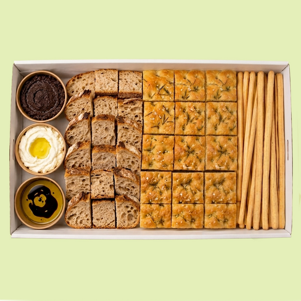 Assorted bread and crackers in a box on a light green background