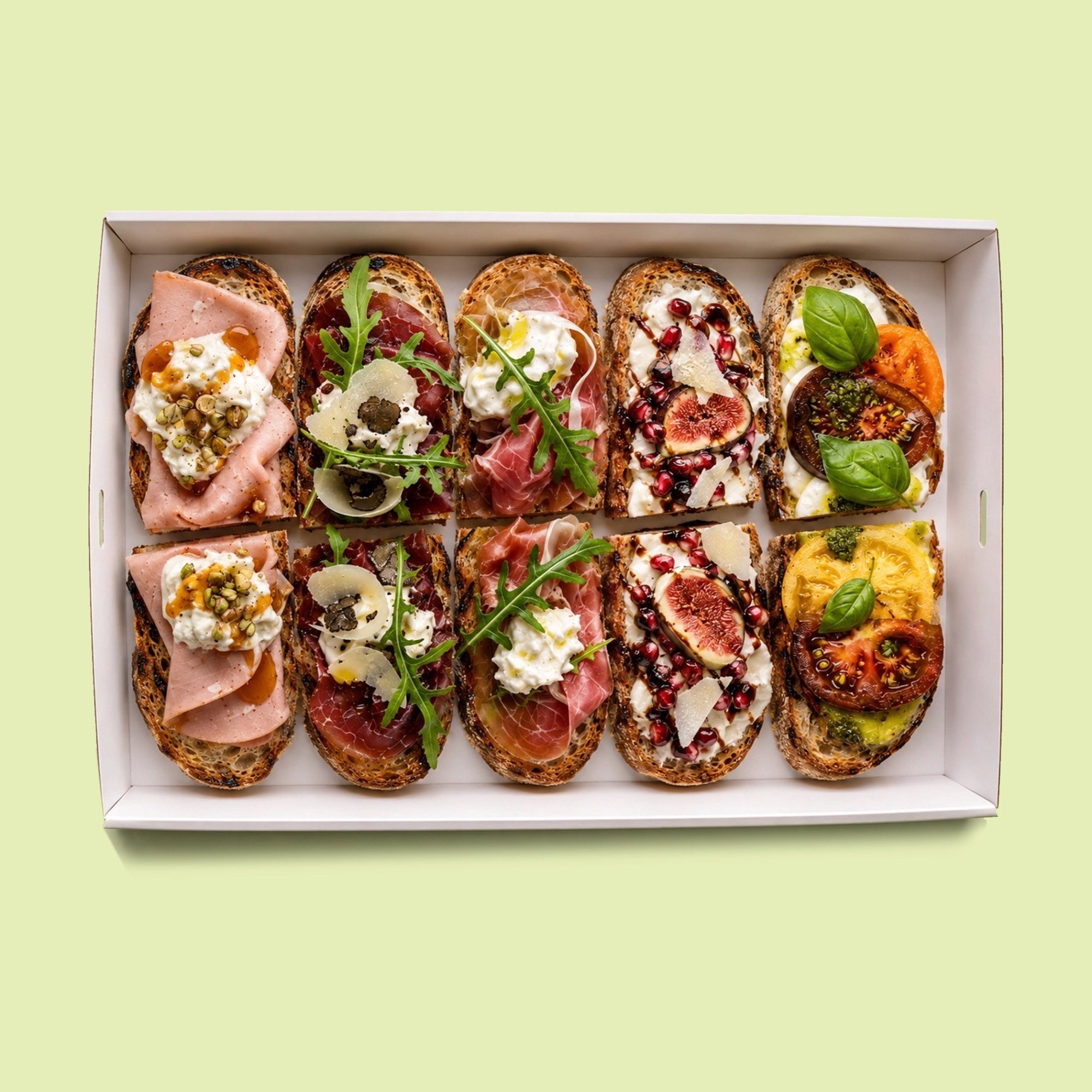 Mixed Italian gourmet crostini platter with heirloom tomato and burrata, fig and pomegranate burrata, prosciutto and rocket, bresaola with truffle and parmesan, and mortadella with honey and pistachio.