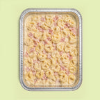 Tray of TORTELLINI pasta with ham and cream on a light green background