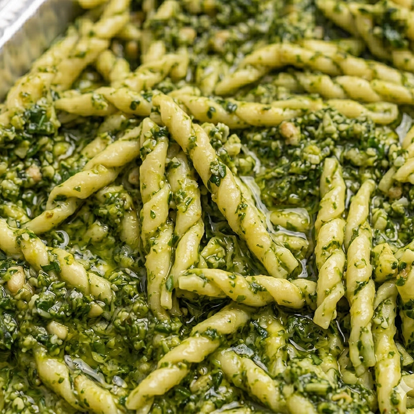 Close-up of green pesto Trofie pasta in a metal pan