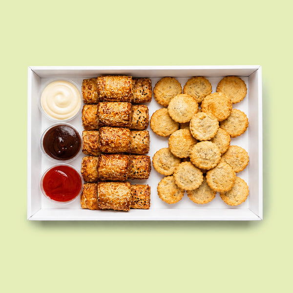 Mixed pie and sausage roll platter with golden party pies and sesame seed sausage rolls, served with tomato sauce, barbecue sauce and aioli.