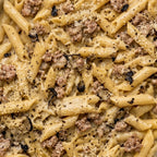 Close-up of penne pasta with pork sausage, truffle, cream and  black pepper for catering office
