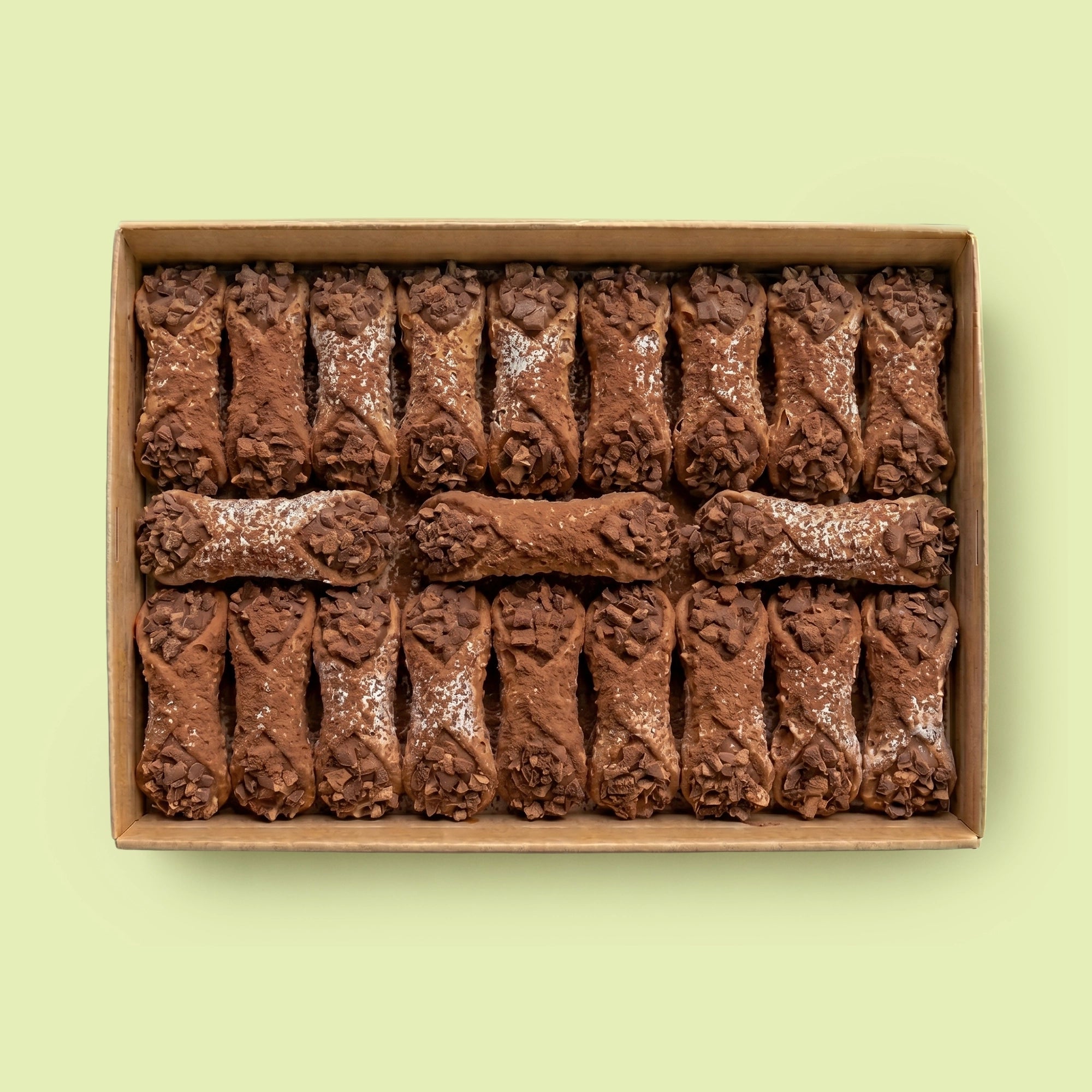 Box of chocolate Cannoli on a light green background