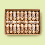 Box of Ricotta Plain cannoli on a light green background