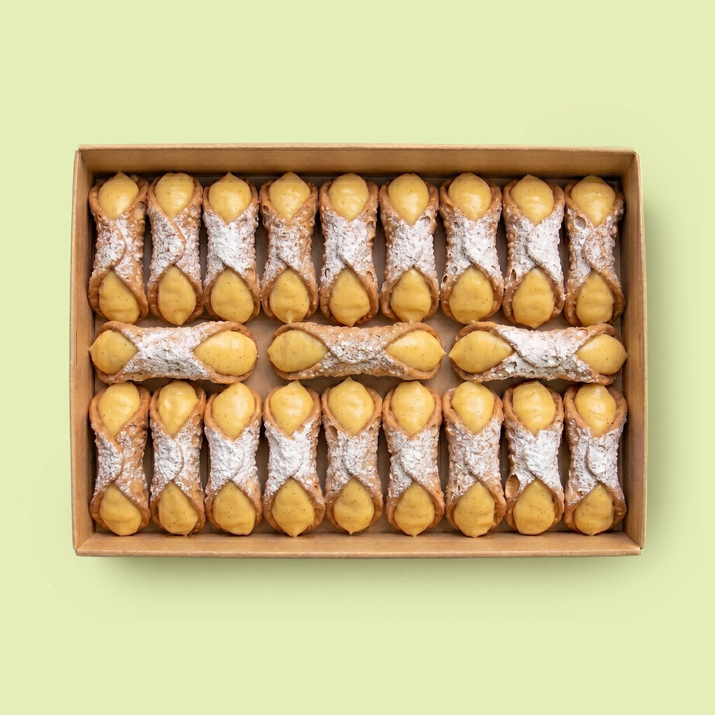Box of cannoli filled with Vanilla Custard Cream on a light green background