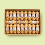 Box of cannoli filled with Vanilla Custard Cream on a light green background