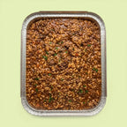 Risotto al Braised Beef Ragù in a catering tray, slow-cooked Arborio risotto with rich braised beef ragù and fresh parsley.