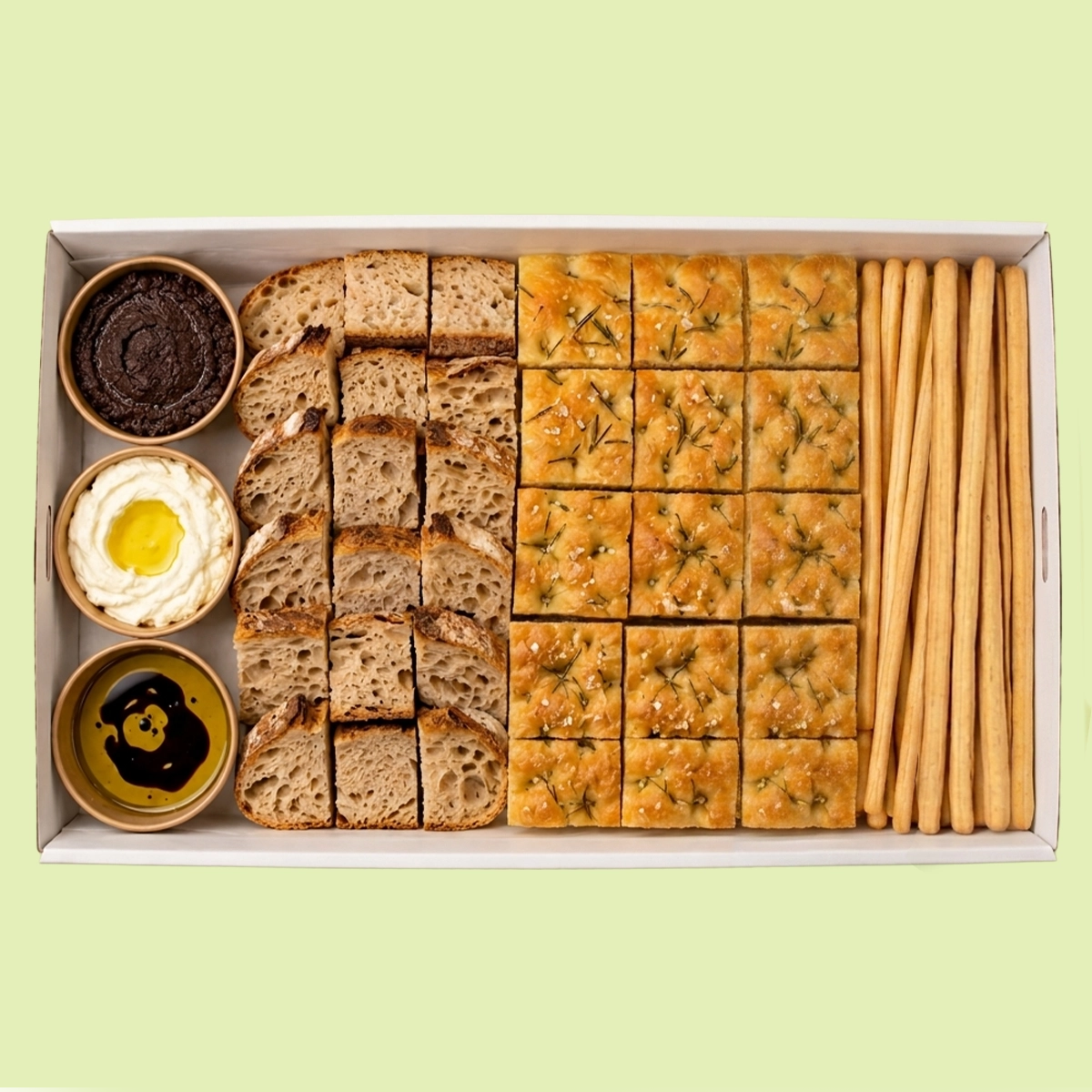 Assorted bread and crackers in a box on a light green background