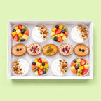 Breakfast catering box with eight pots of fresh fruit salad and Greek yoghurt with granola, and five almond friands.