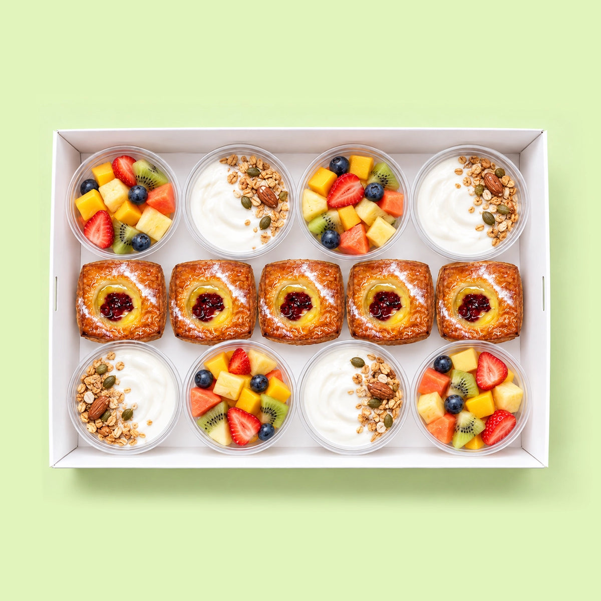 Breakfast catering box with eight pots of fresh fruit salad and Greek yoghurt with granola, and five mini Danish pastries with jam and custard.