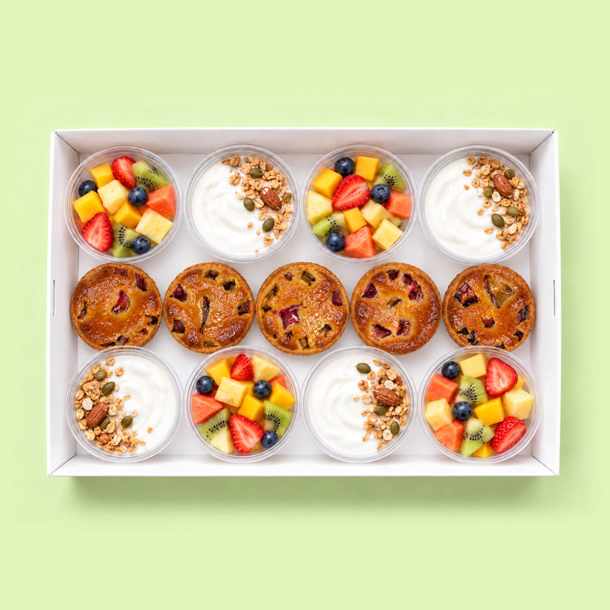 Breakfast catering box with eight pots of fresh fruit salad and Greek yoghurt with granola, and five mini frangipane fruit tarts.