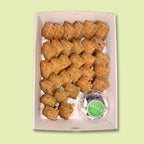 Box of banana bread bites with a small container of butter labeled 'Eatalo' on a light green background