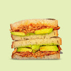 Sandwich with avocado and chicken on a light green background