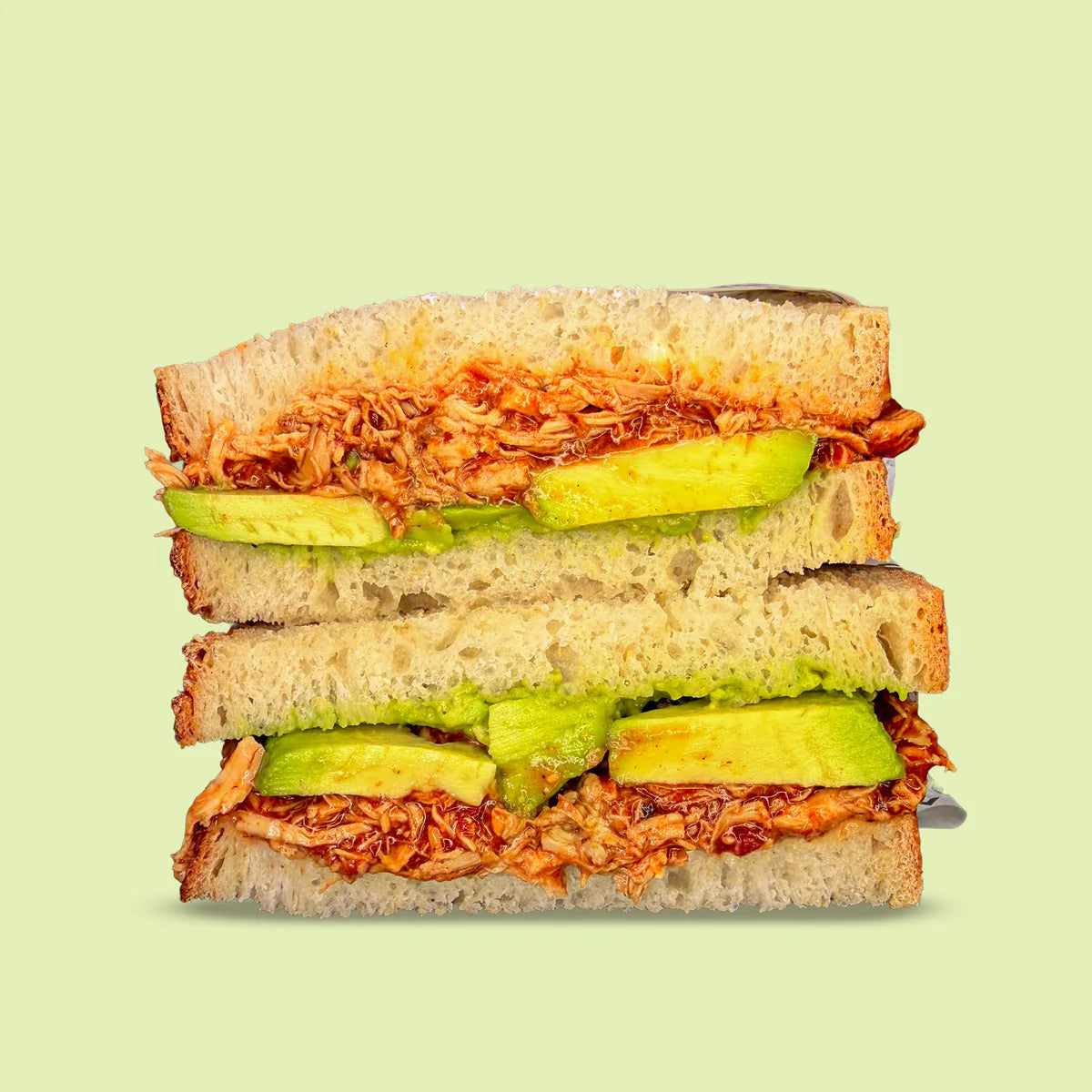 Sandwich with avocado and chicken on a light green background