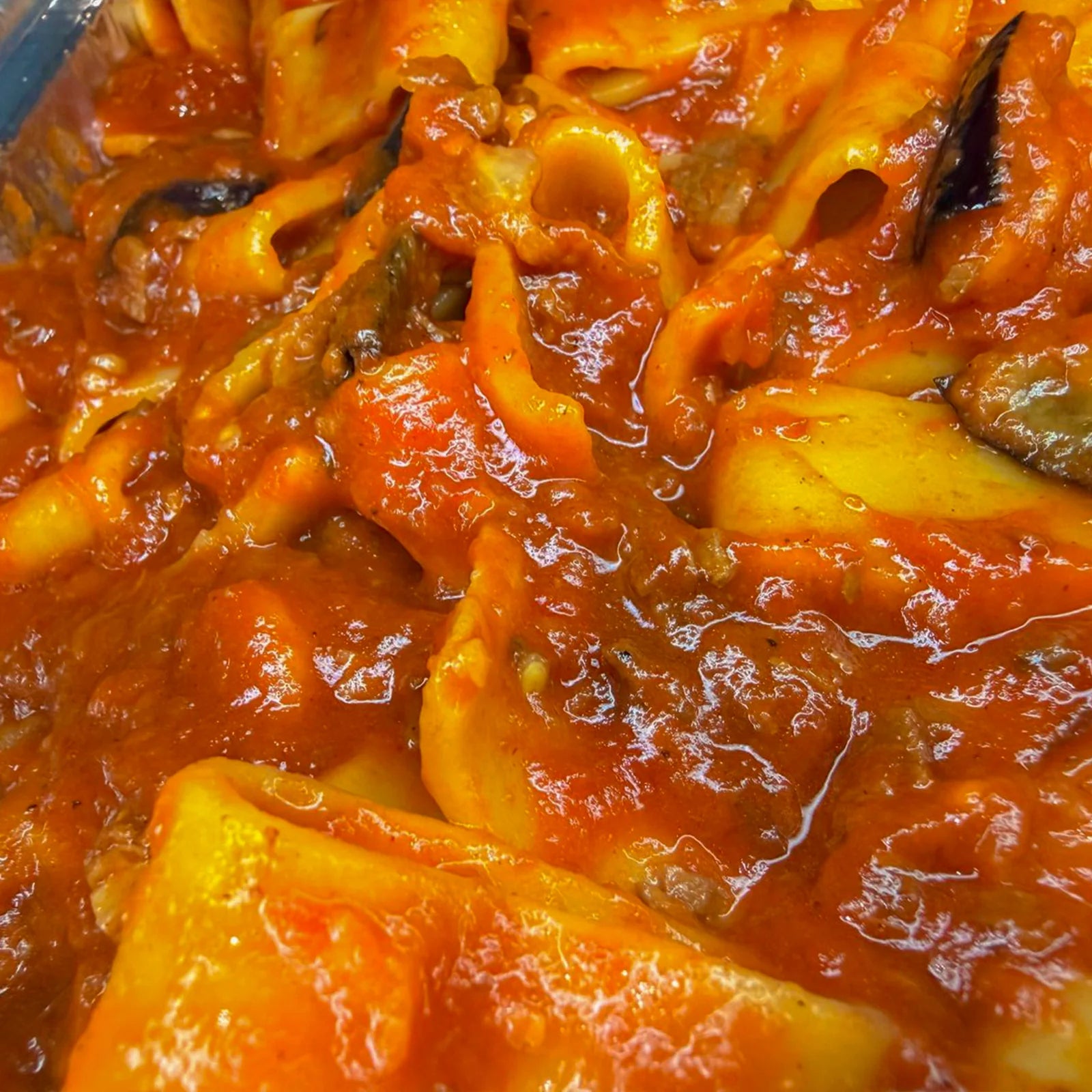 Close-up of pasta with oxtail beef tomato red sauce and eggplants
