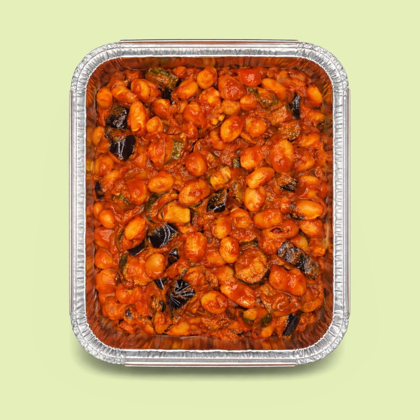 Italian pasta gnocchi with Norma tomato sauce and eggplant in a metal tray on a light green background