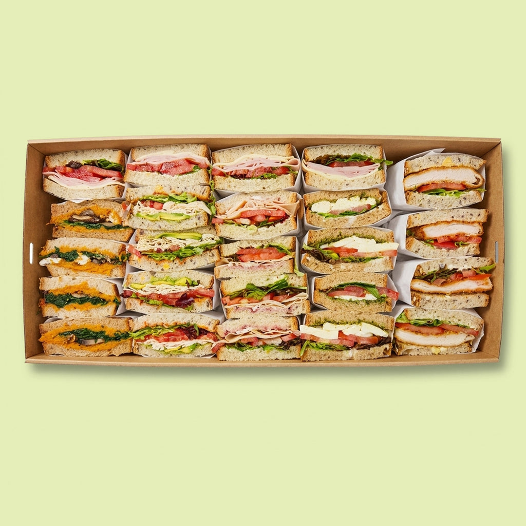 Large box of assorted Italian sandwiches on a light green background