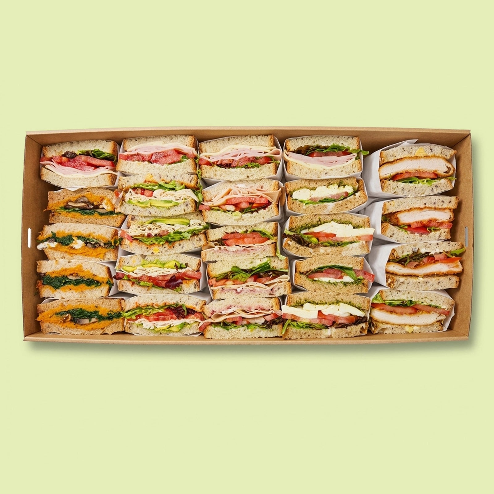 Large box of assorted Italian sandwiches on a light green background