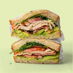 Half-cut sandwich with chicken, ham, avocado, and lettuce for catering in Sydney.