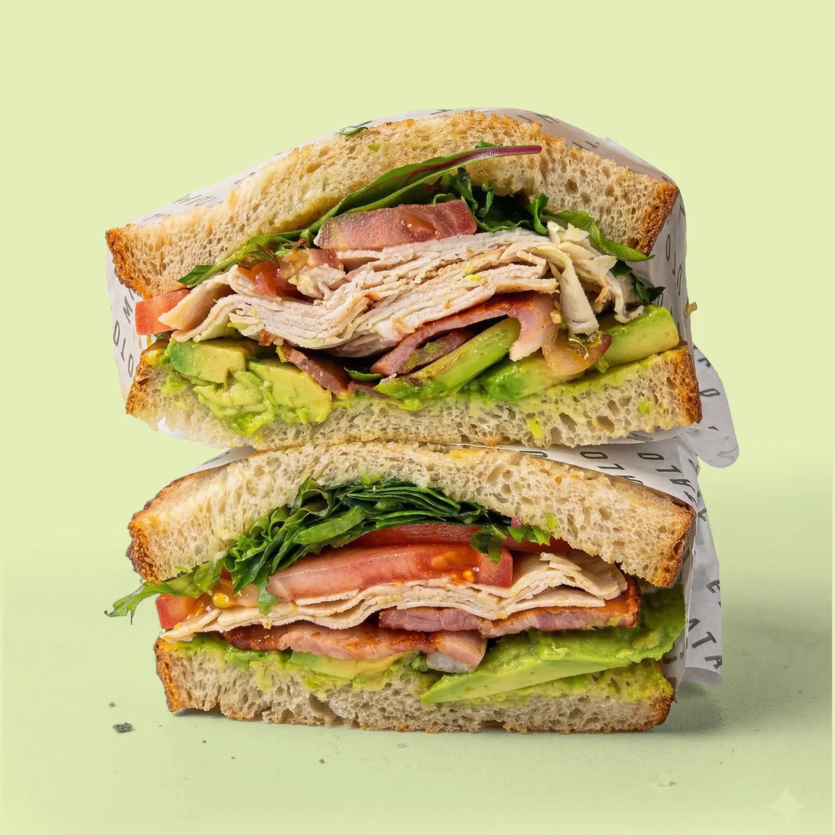 Half-cut sandwich with chicken, ham, avocado, and lettuce for catering in Sydney.