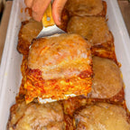 Square of lasagna being lifted with a spatula from a dish during a office catering lunch